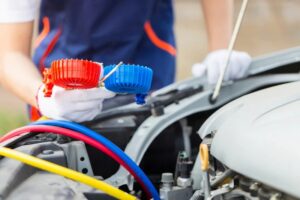 Repairman holding monitor tool to check and fixed car air condition